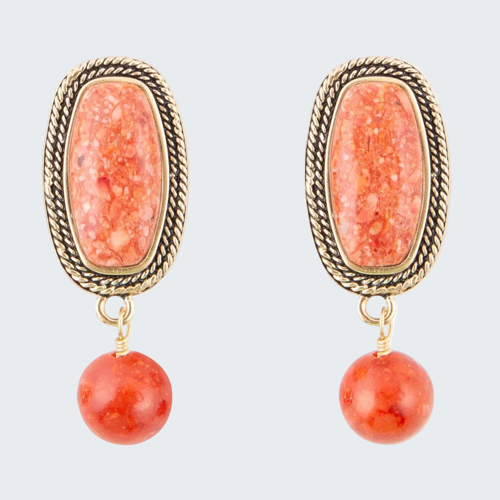 Pair of earrings with orange stone and gold frame on a white background