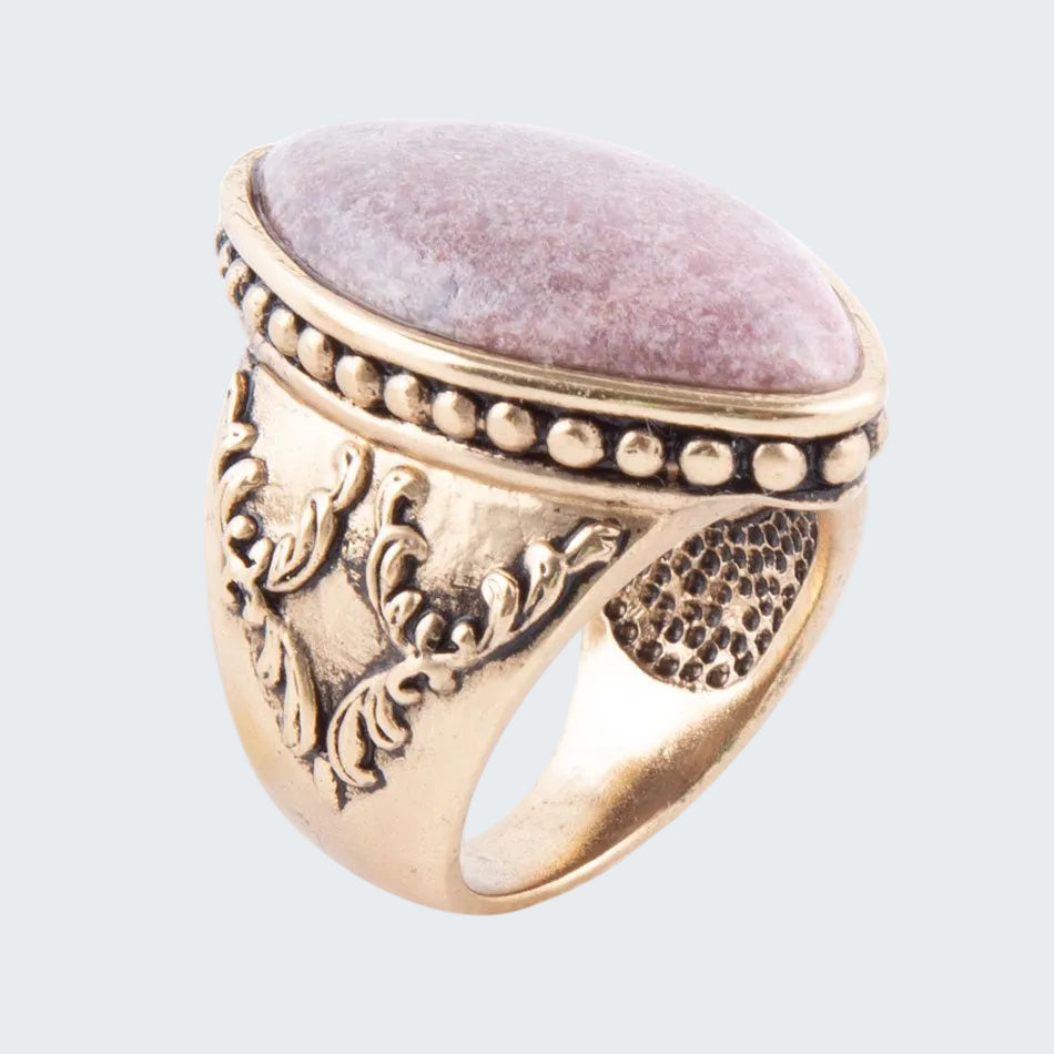 Gold ring with pink stone on a white background
