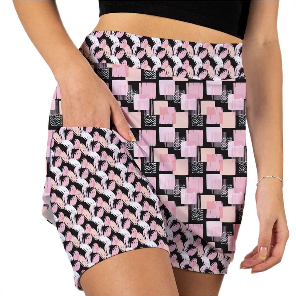 Person wearing a patterned skirt with pink and black geometric design.