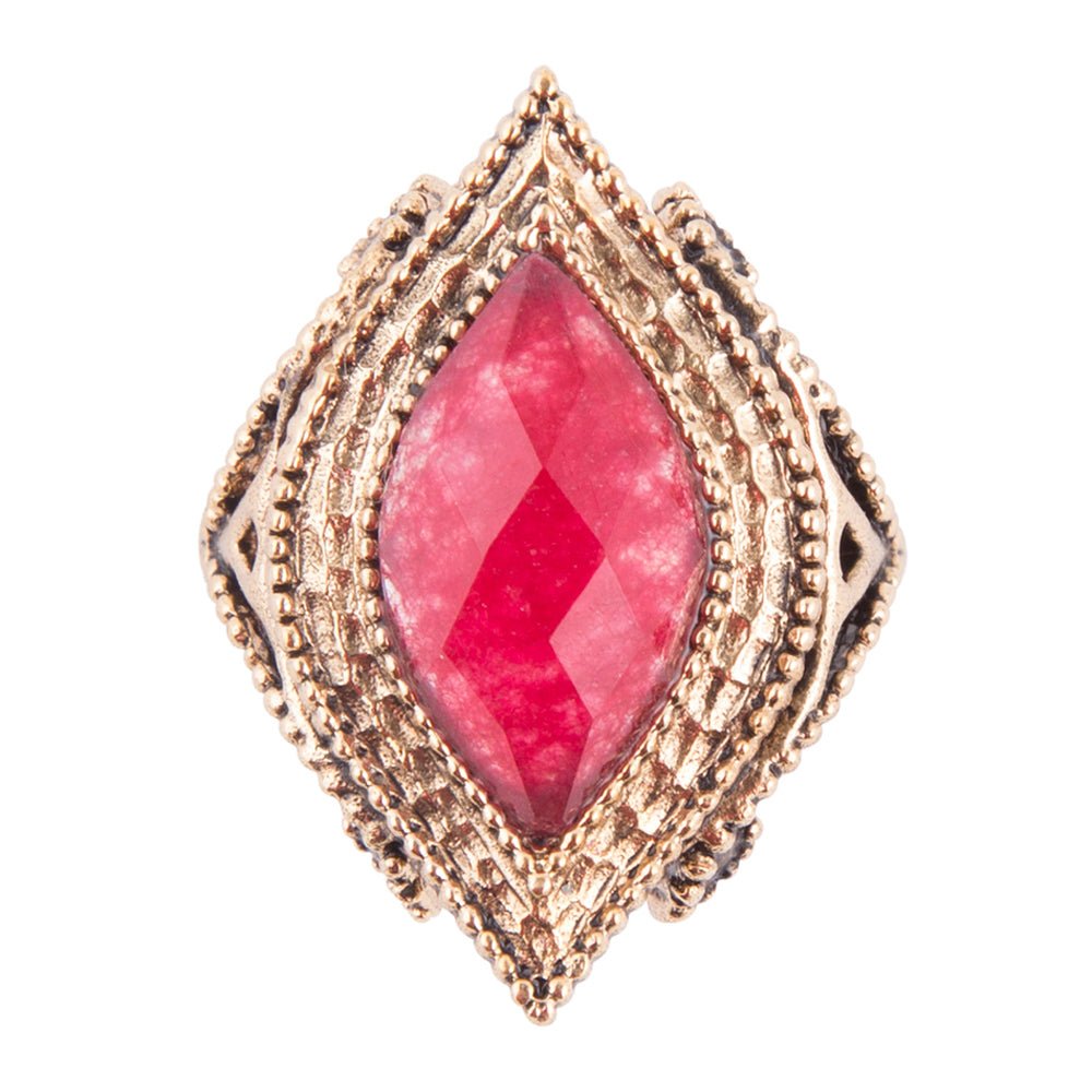 Ring with pink gemstone and gold-tone setting on a white background