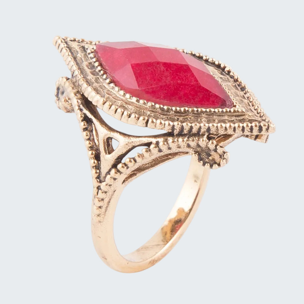 Gold ring with a red gemstone on a white background