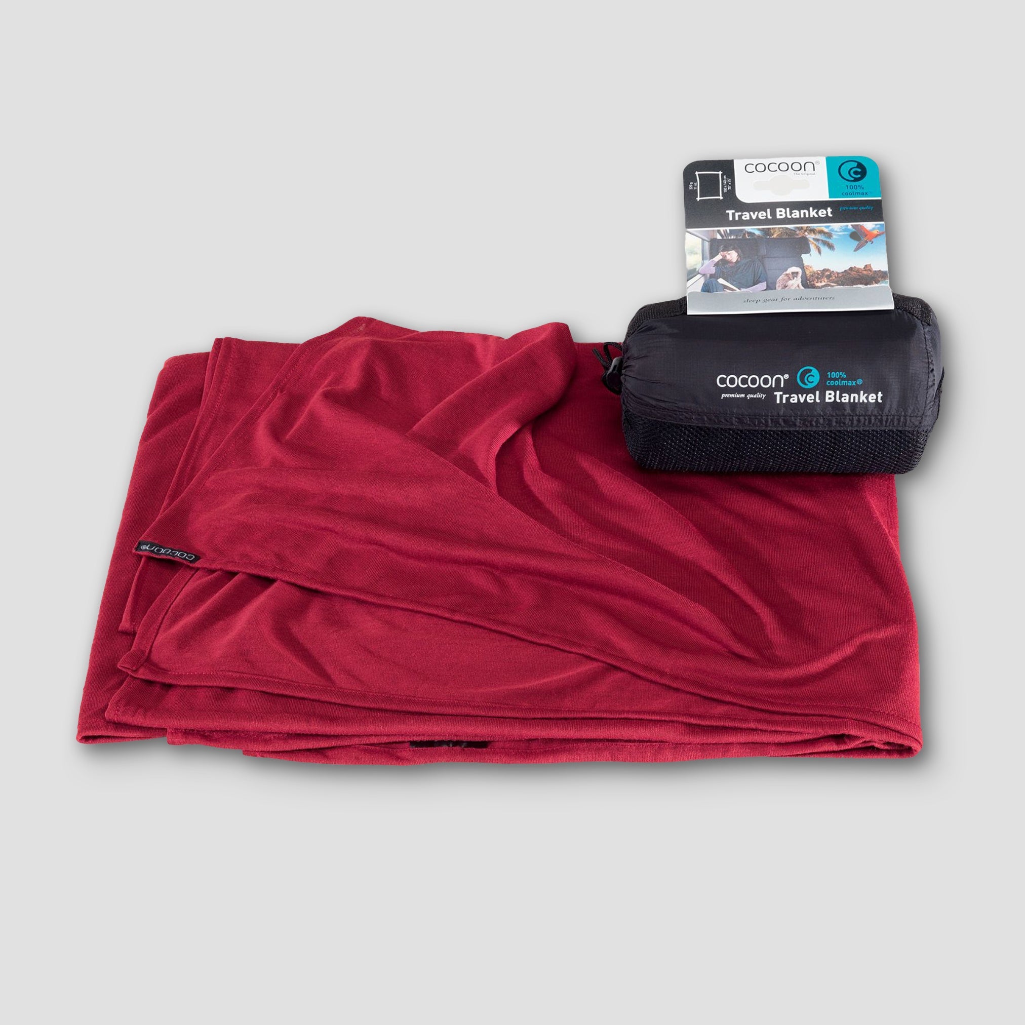 Red travel blanket with packaging on a light gray background