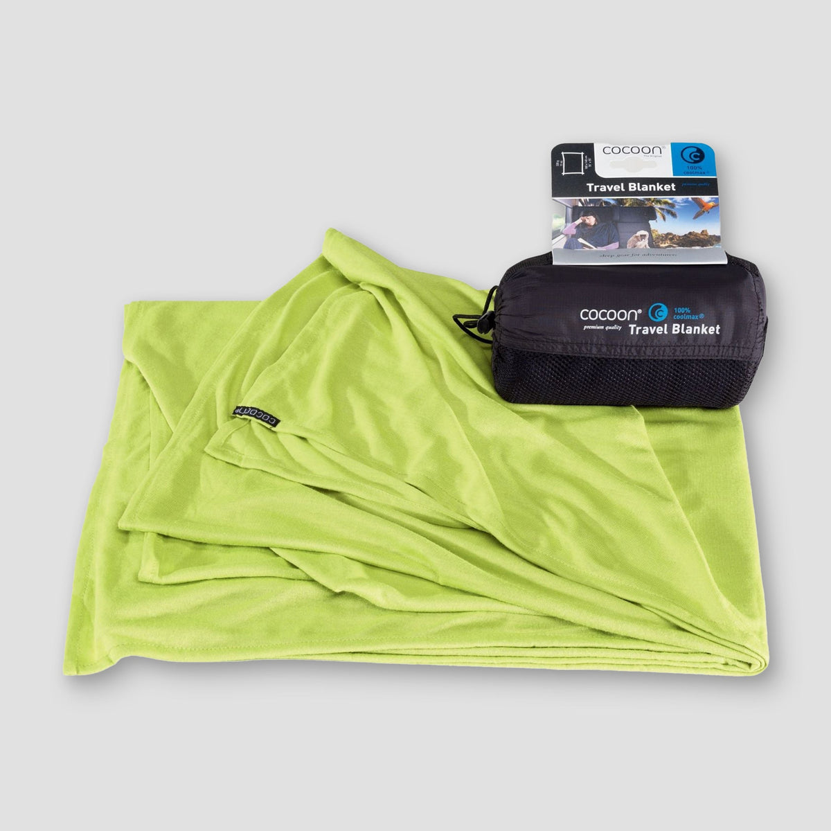 Green travel blanket with packaging on a gray background