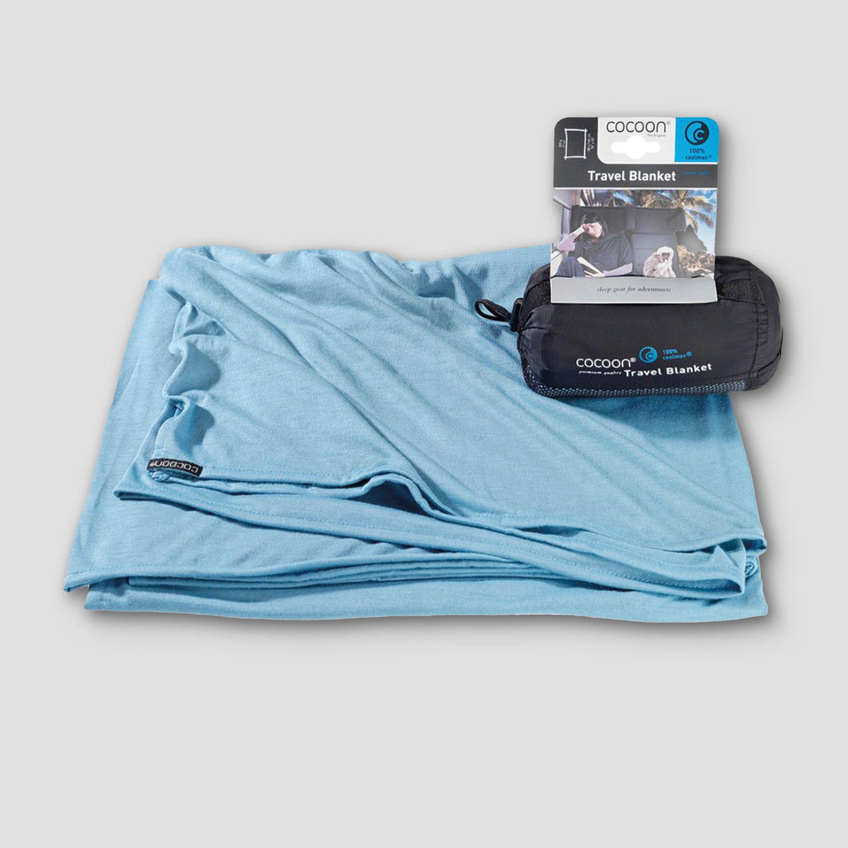 Blue travel blanket with packaging on a light gray background