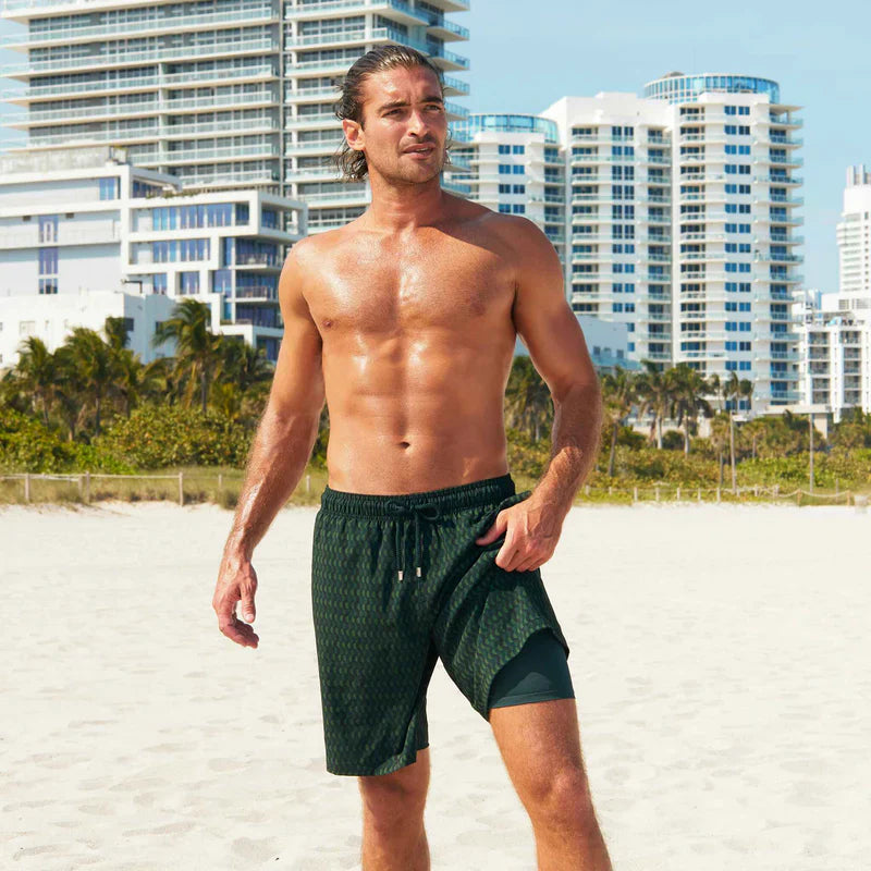 Man standing on a beach with buildings in the background