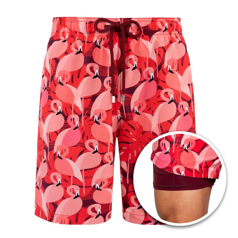 Red swim shorts with pink flamingo pattern on a white background