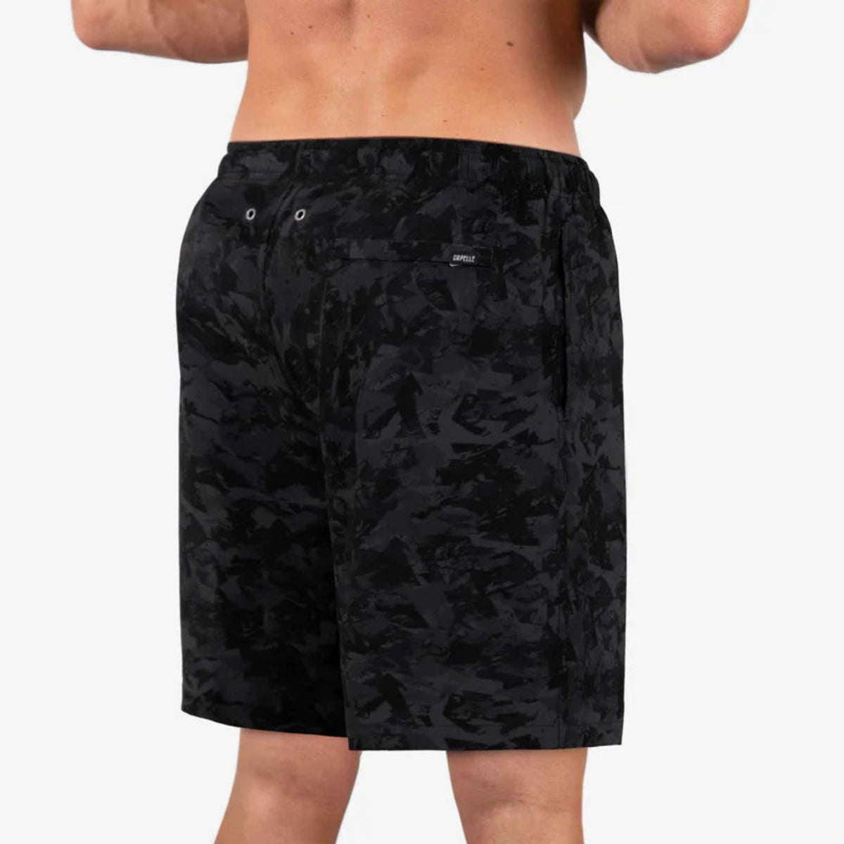 Black camouflage shorts worn by a person on a white background