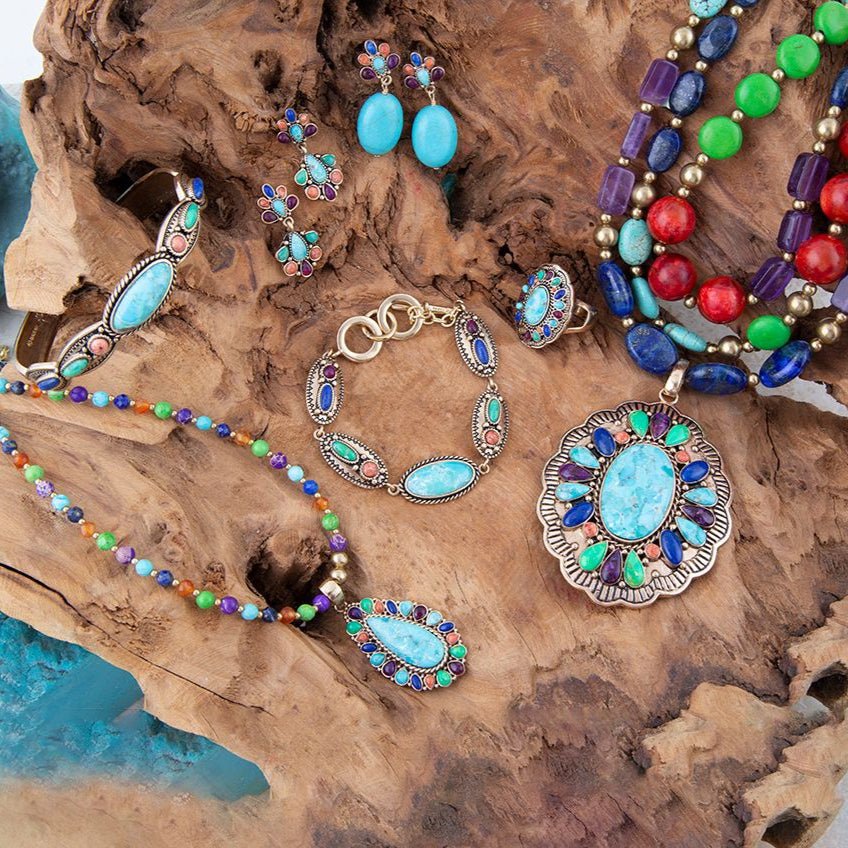 Colorful jewelry set including necklaces, earrings, and bracelet on a wooden surface