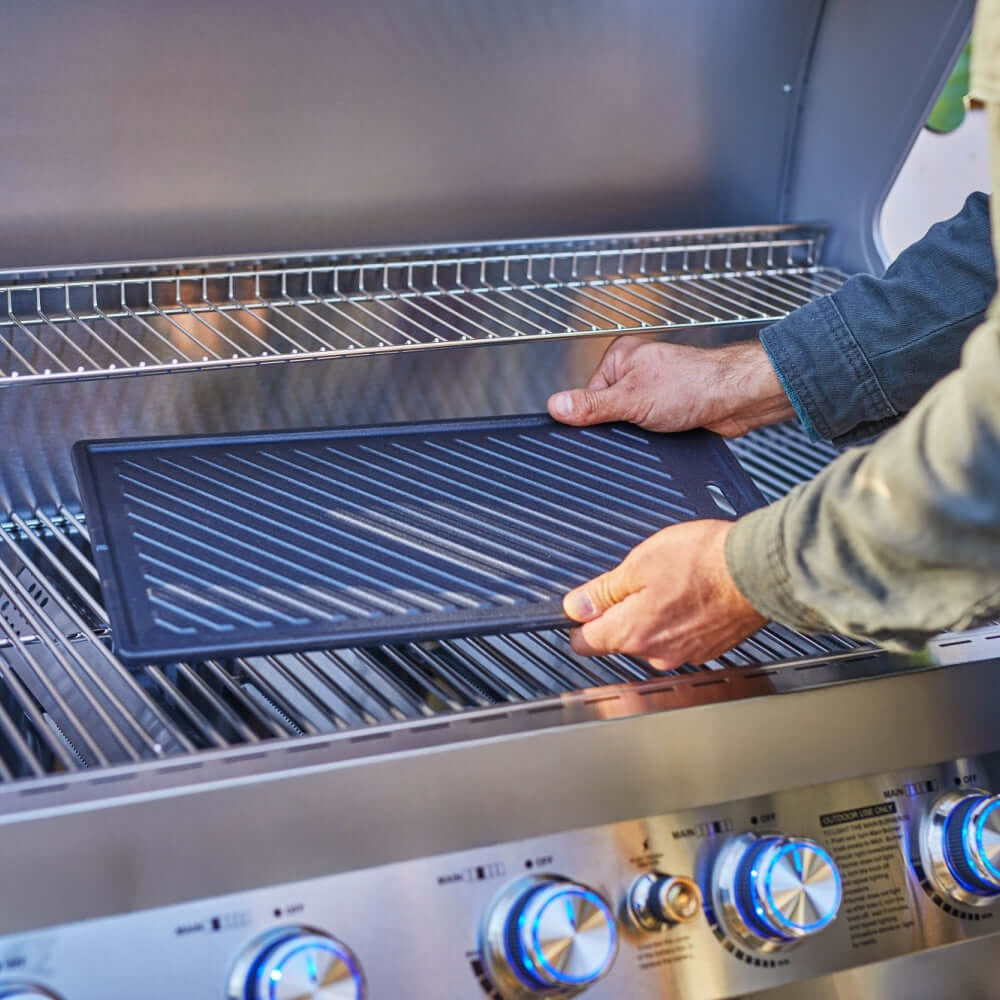 Person cleaning a grill with a brush