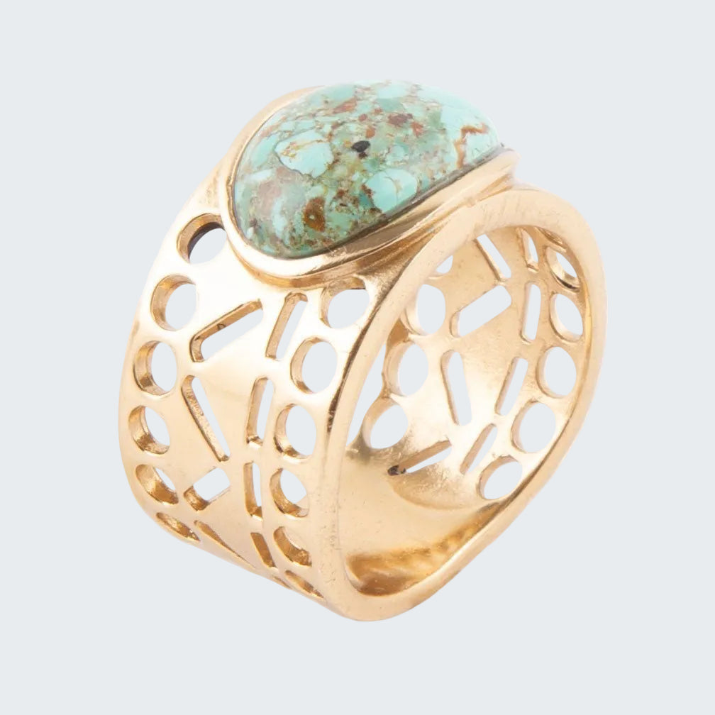 Gold ring with turquoise stone on a white background