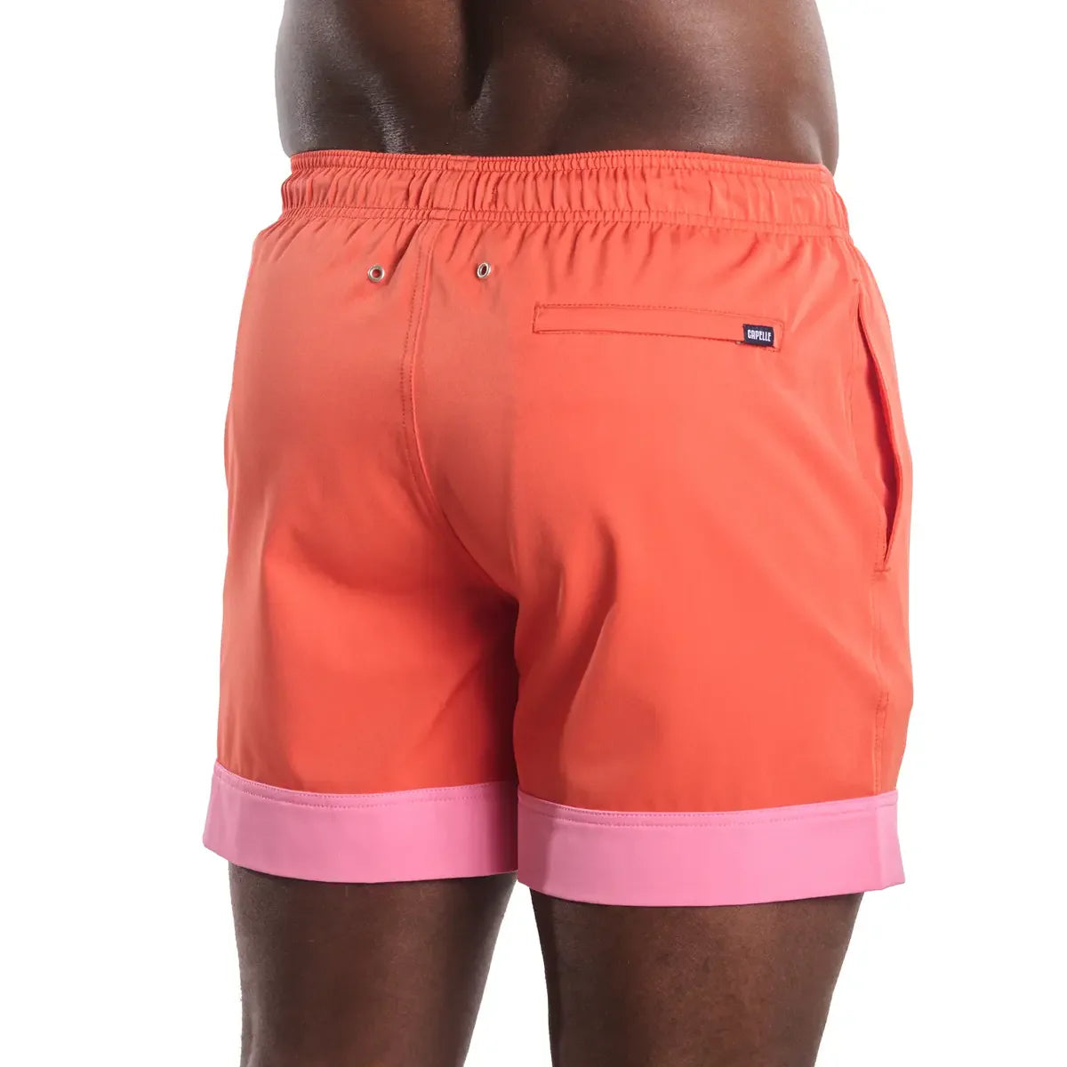 Orange swim shorts with pink trim on a white background