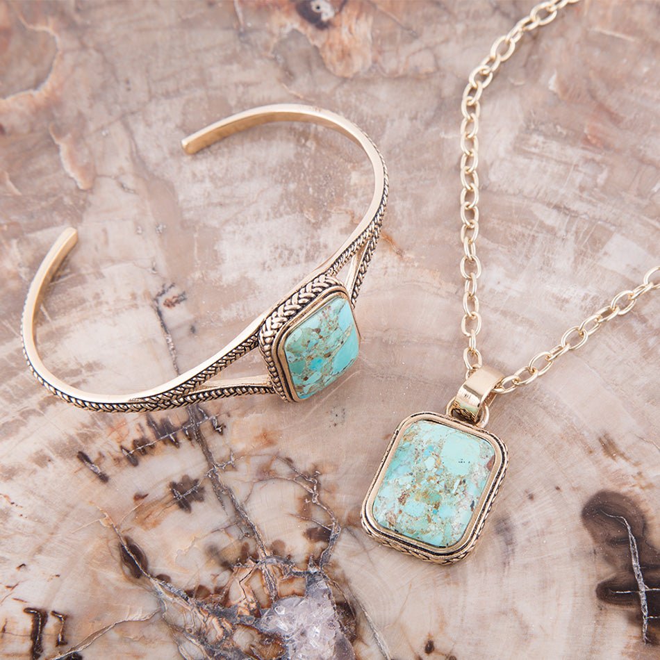 Turquoise stone jewelry set on a textured surface
