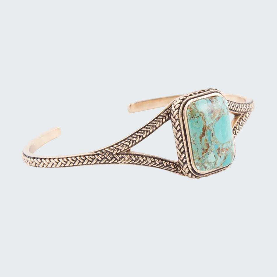 Turquoise stone bracelet with gold detailing on a white background