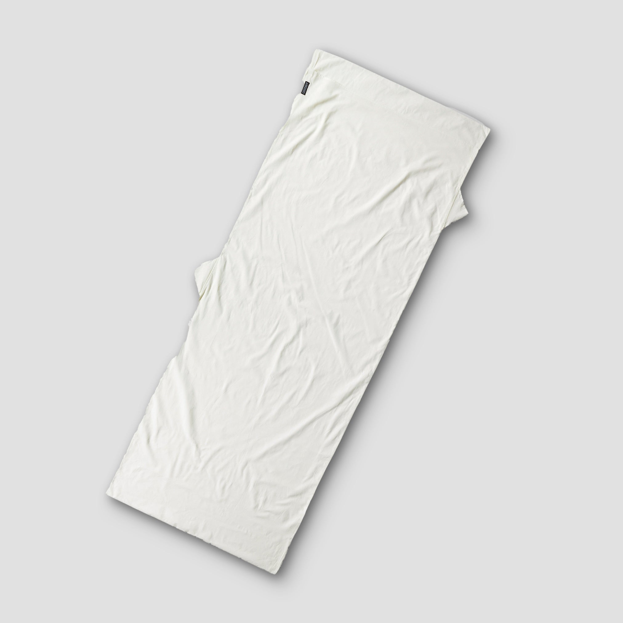White sleeping bag on a light gray background