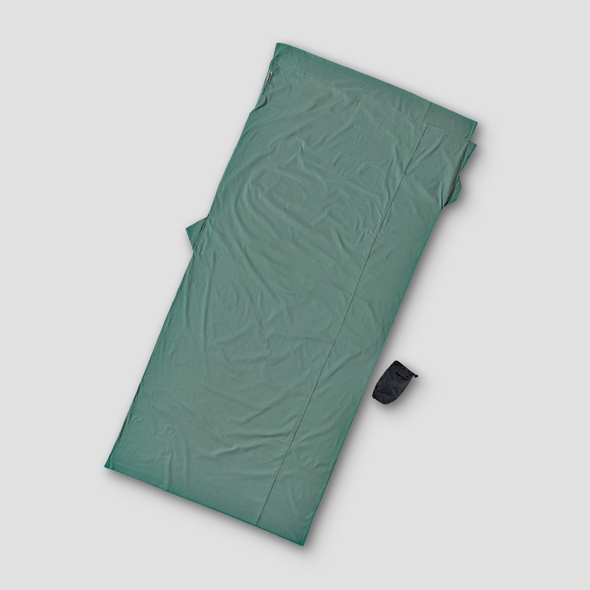 Green sleeping bag on a light gray background