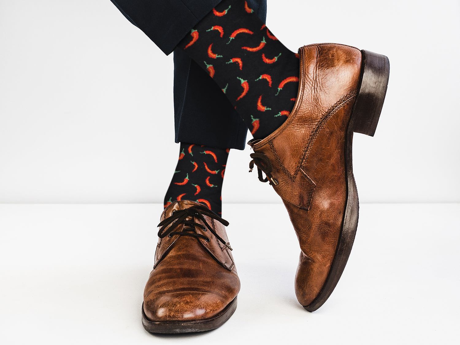 Brown dress shoes and patterned socks on a white background