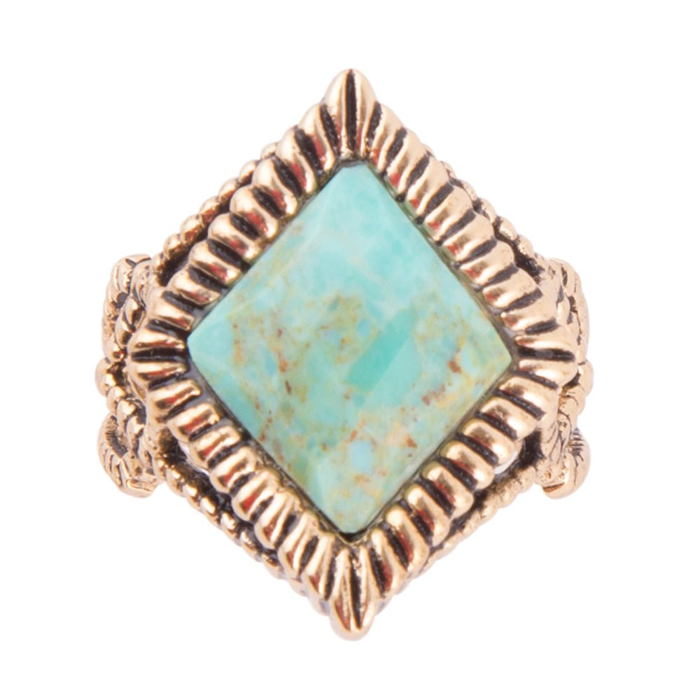 Turquoise stone ring with gold-tone metal band on a white background