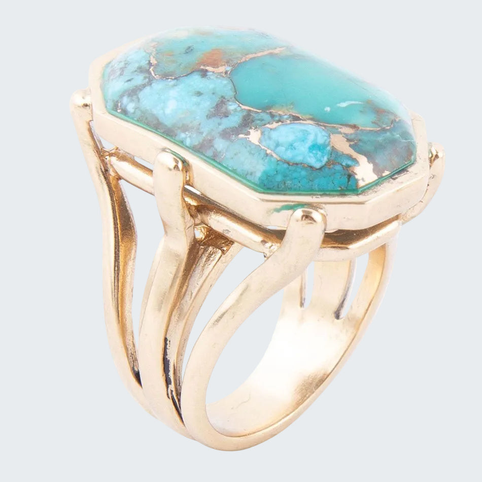Gold ring with a large turquoise stone on a white background