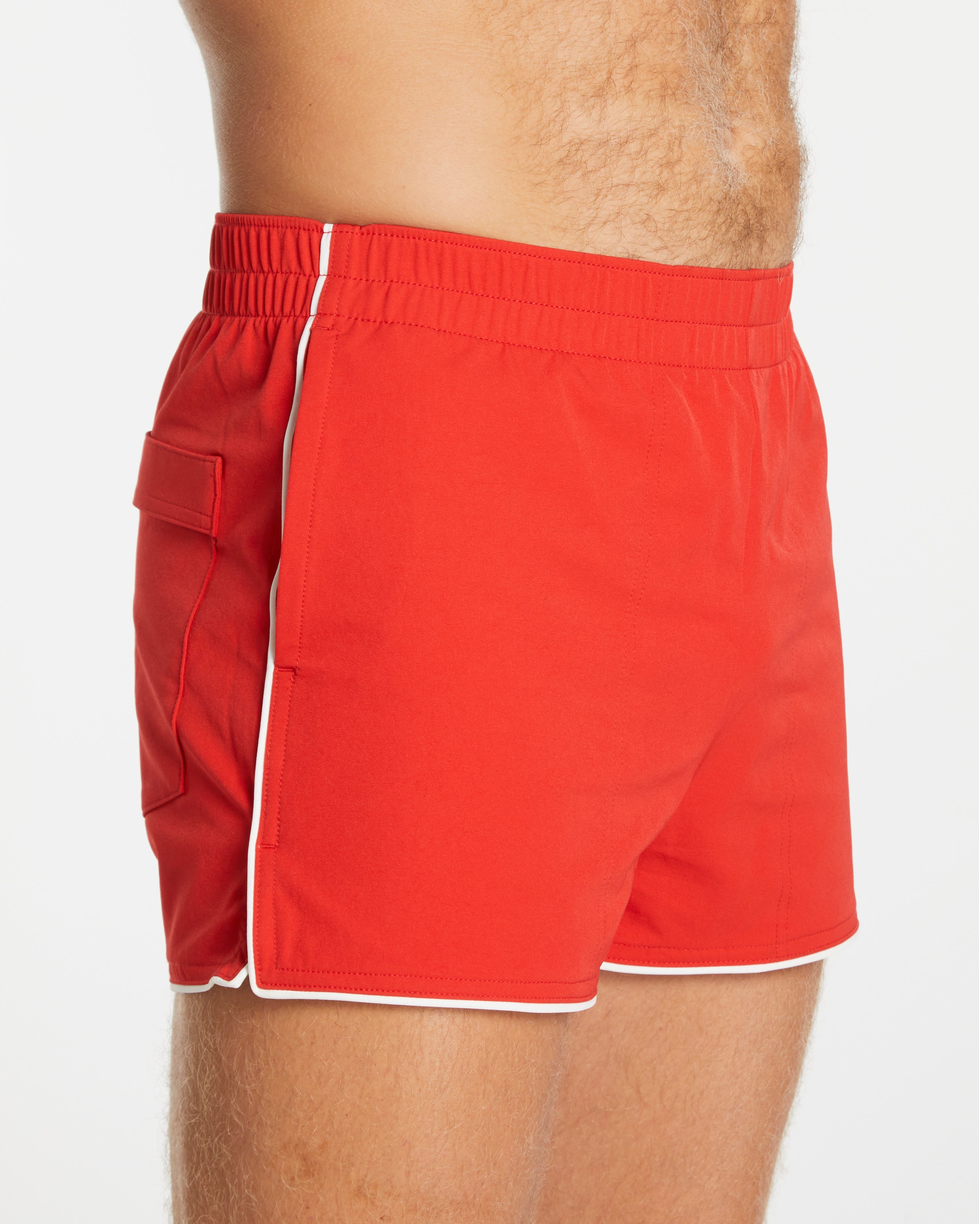 Red swim shorts with white trim on a white background