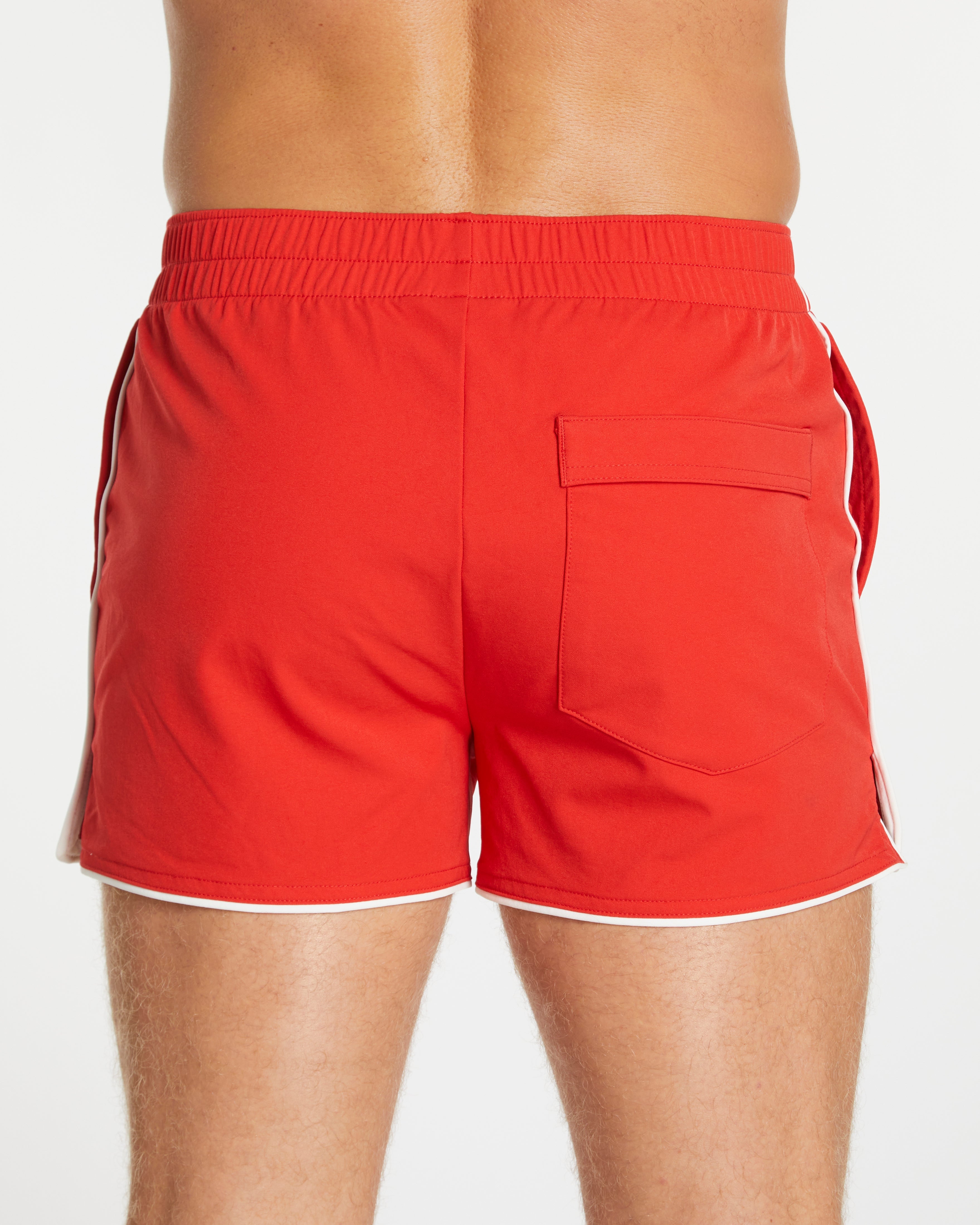 Red swim shorts with white trim on a plain background