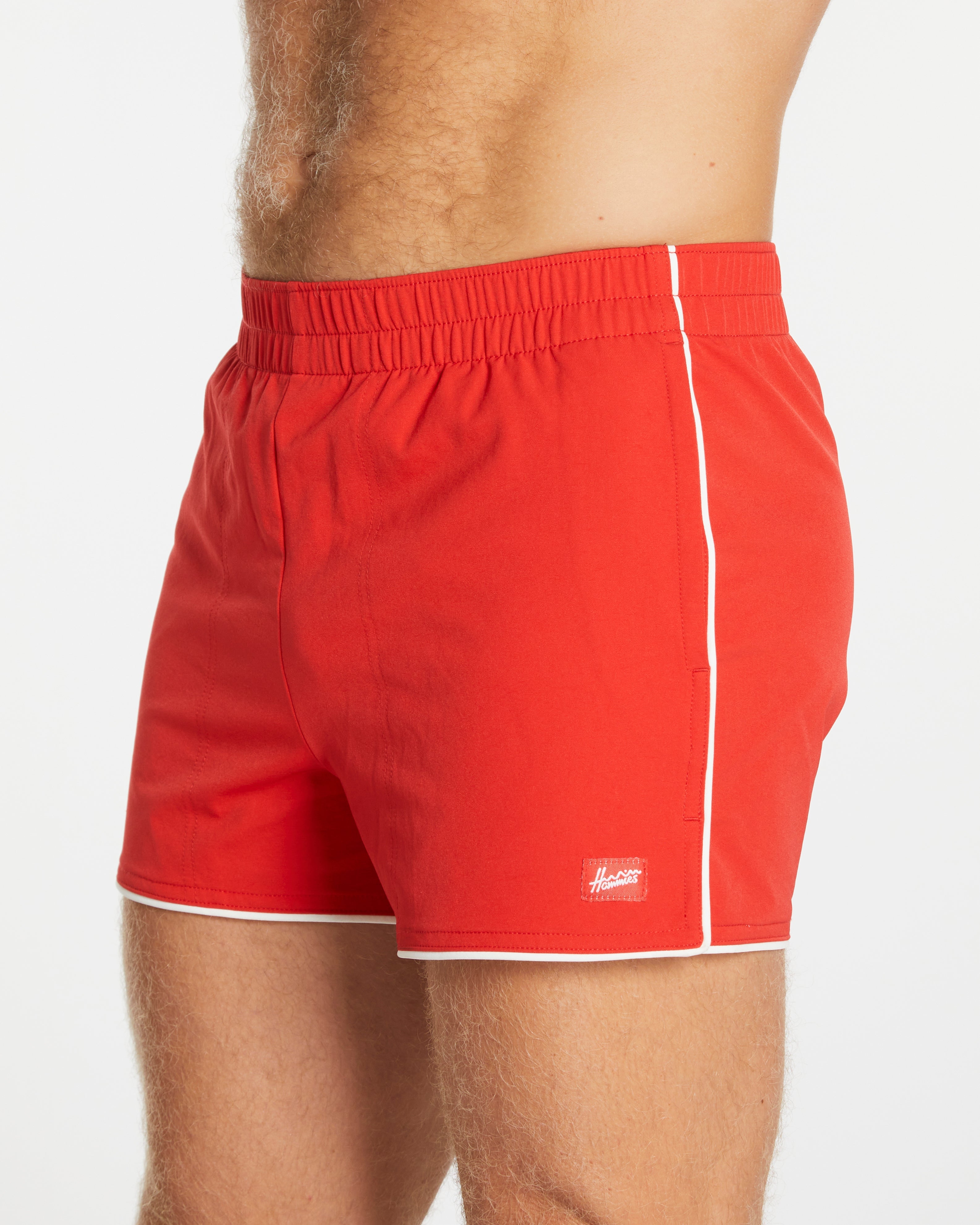 Red swim shorts with a white stripe on a white background