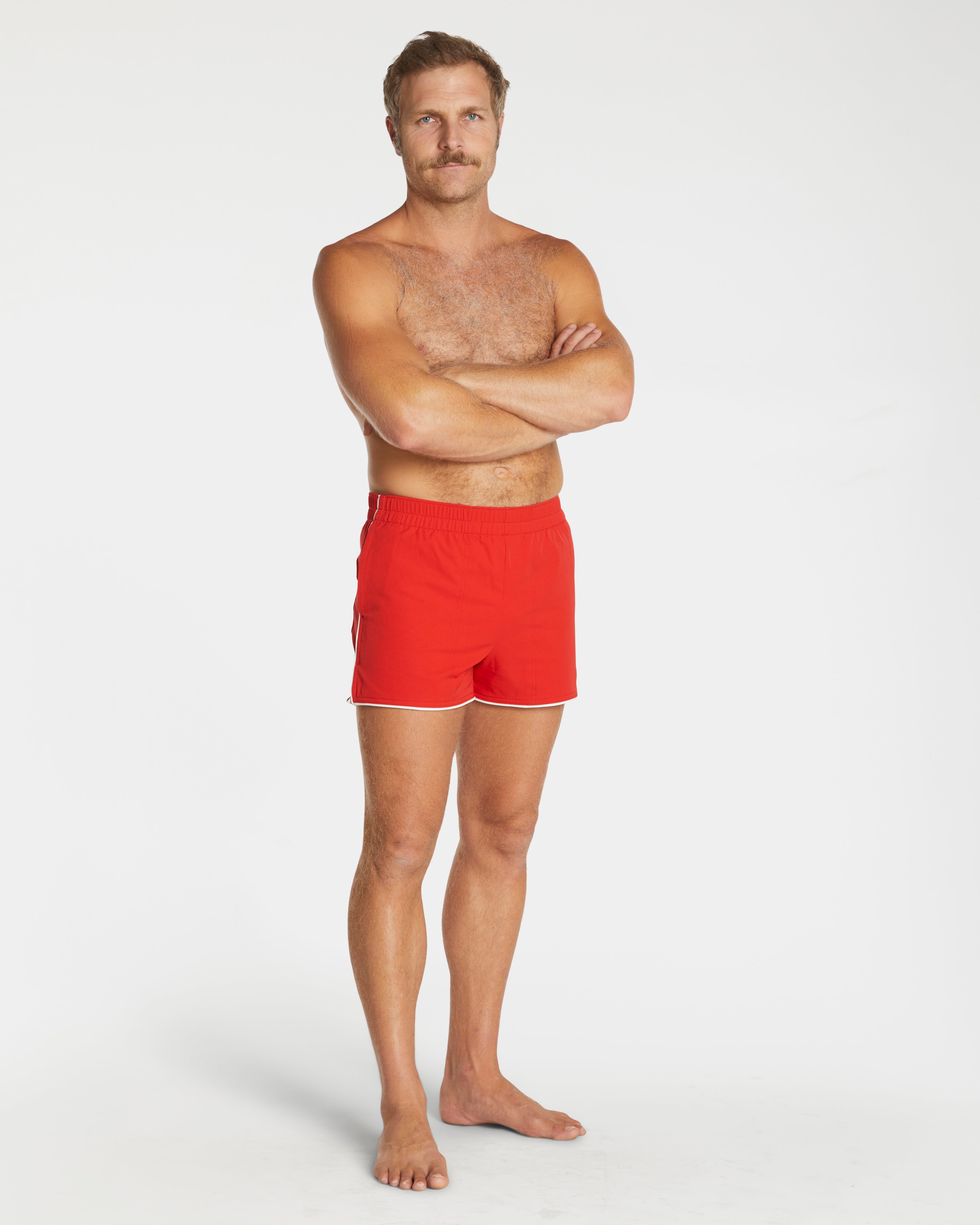 Man wearing red swim shorts on a white background