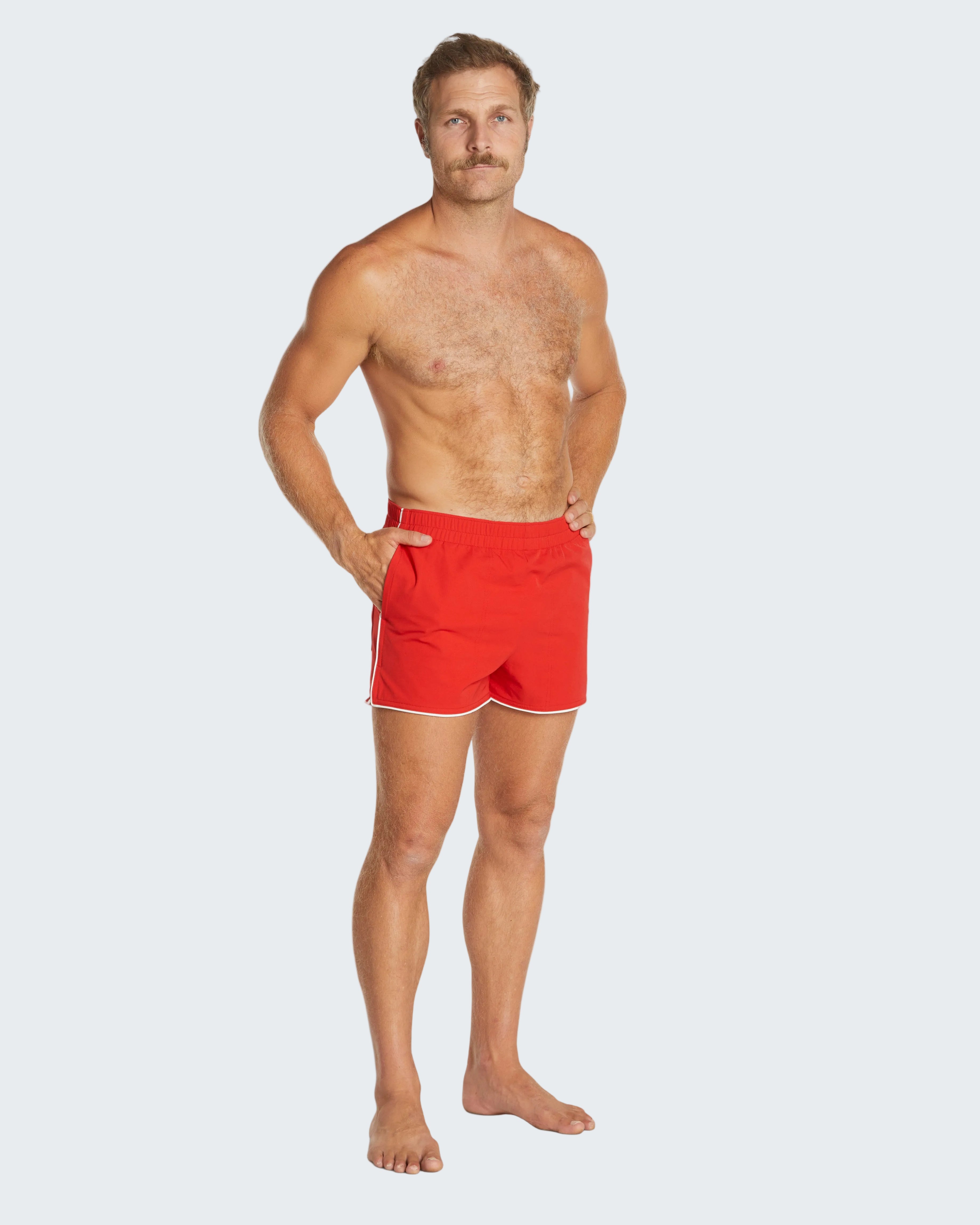 Man wearing red swim shorts on a white background