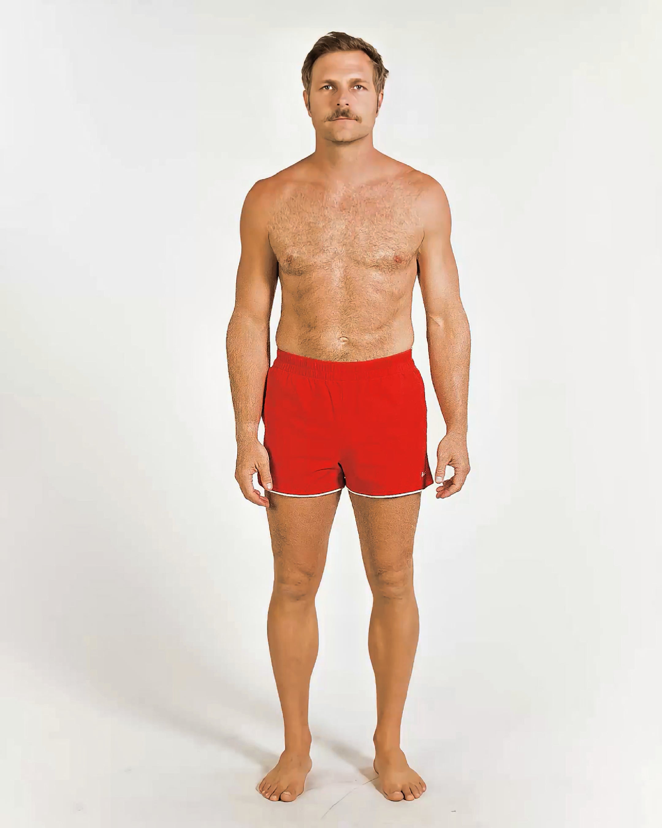 Man wearing red swim shorts on a white background