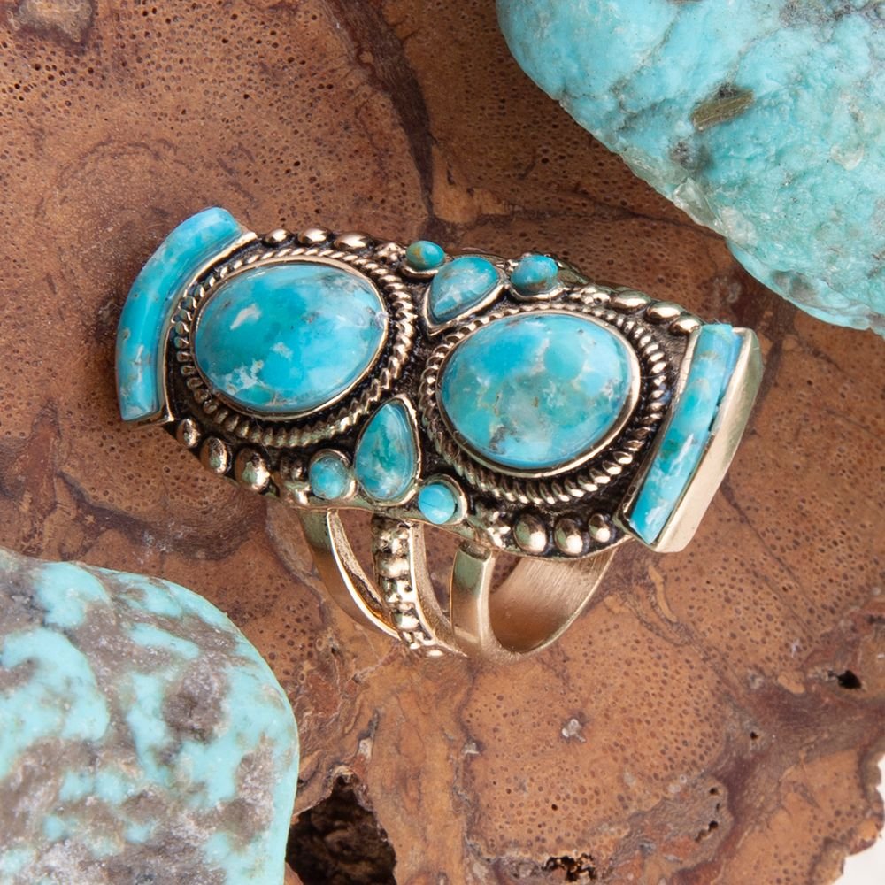Turquoise stone ring with silver band on a textured brown surface