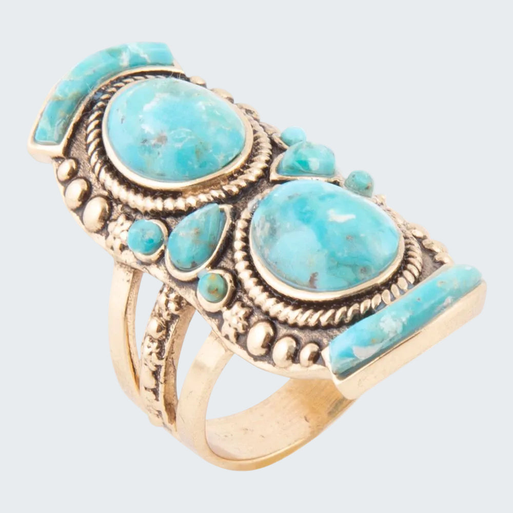 Turquoise stone ring with gold accents on a white background