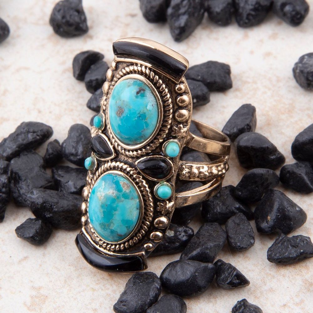 Ornate ring with turquoise stones on black stones