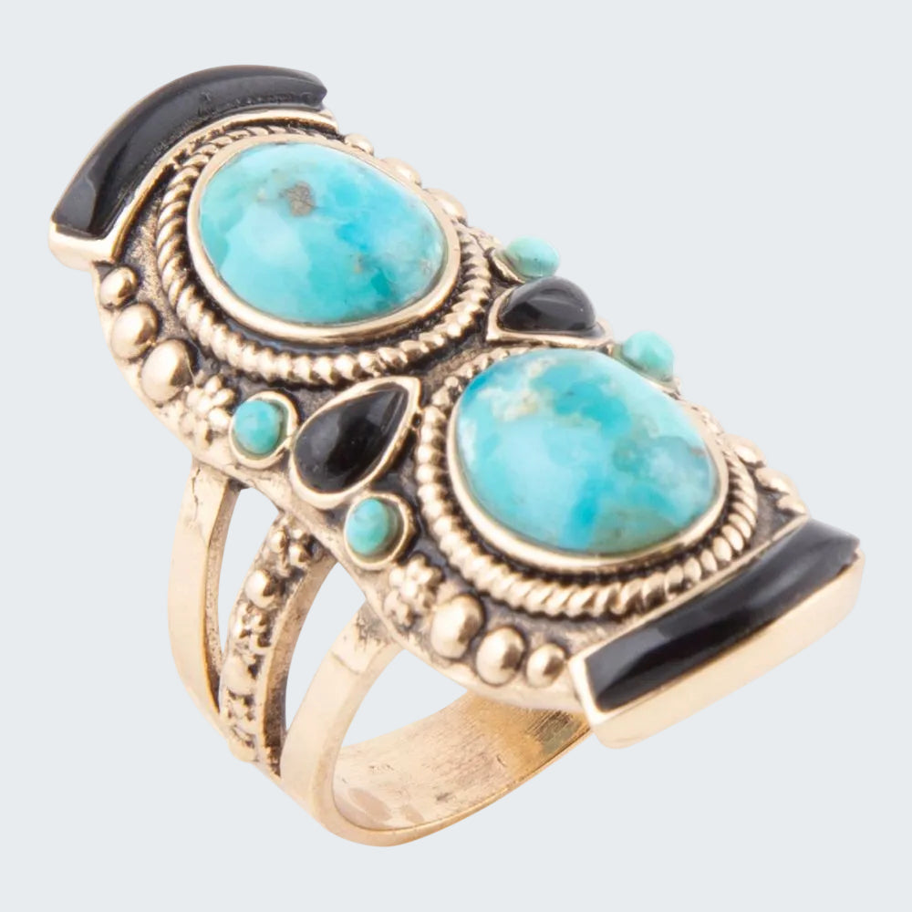 Ring with turquoise stones and gold accents on a white background