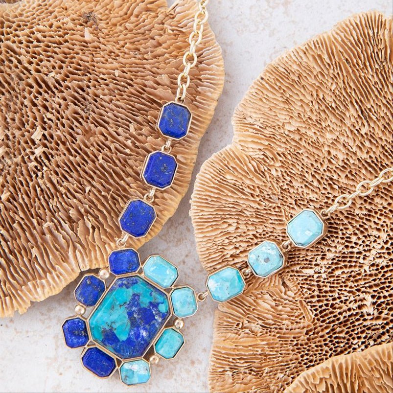 Necklace with blue and turquoise stones on a textured beige surface