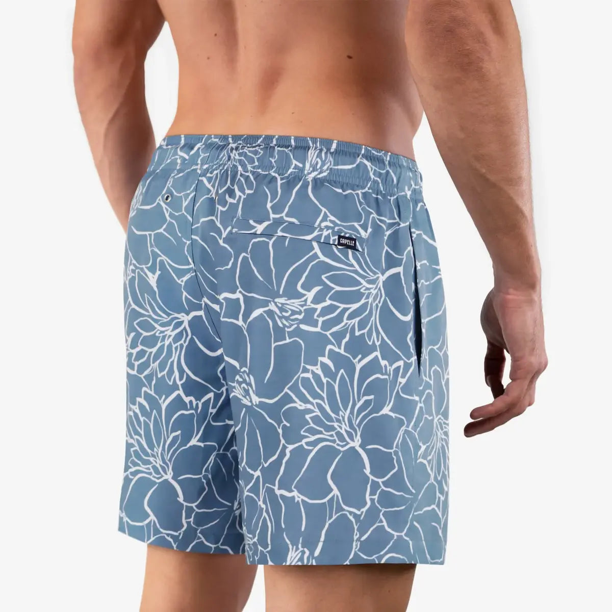 Blue floral-patterned swim shorts worn by a person on a white background