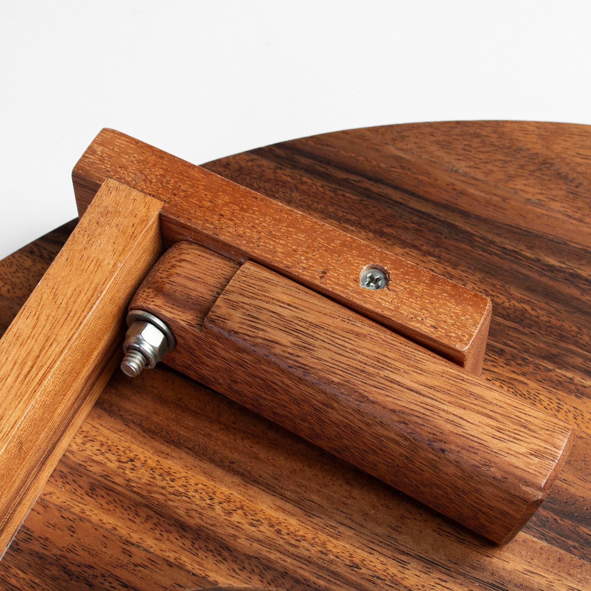 Close-up of a wooden chair with a metal screw on a white background