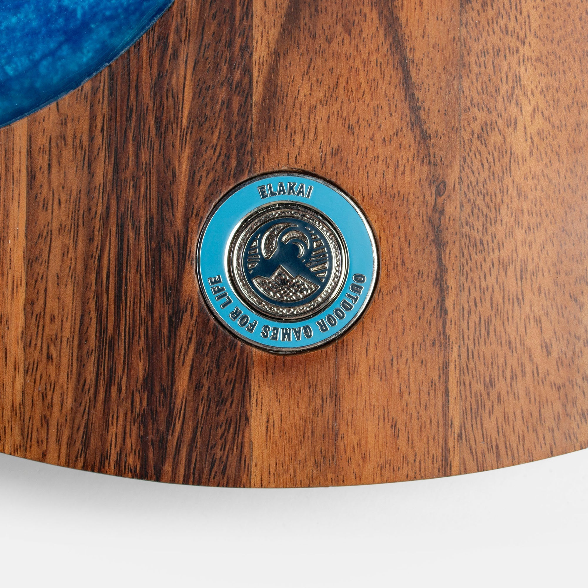 Close-up of a wooden product with a blue and silver Elakai logo.