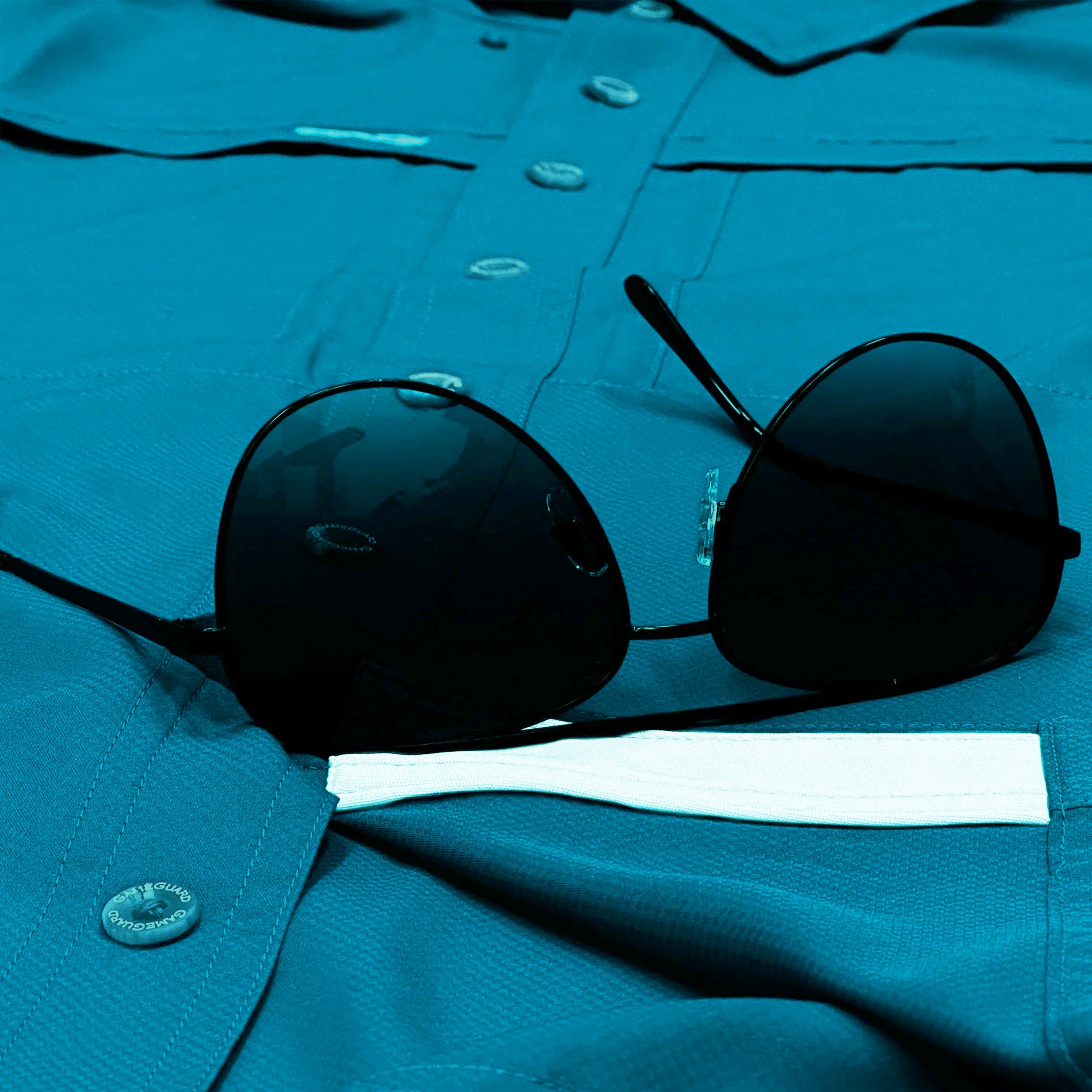 Black sunglasses on a blue shirt with a white tie