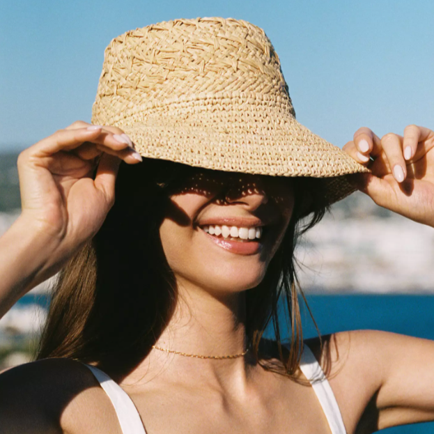 Woman wearing a straw hat with a scenic background