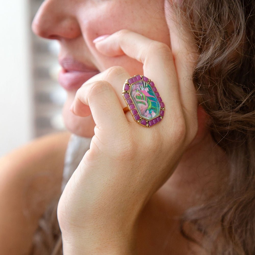 Close-up of a hand wearing a colorful ring with a decorative design.