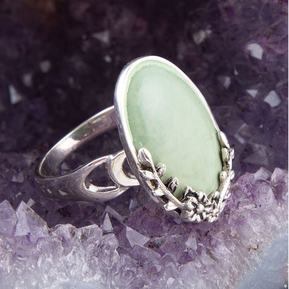 Silver ring with a green stone on a purple crystal background