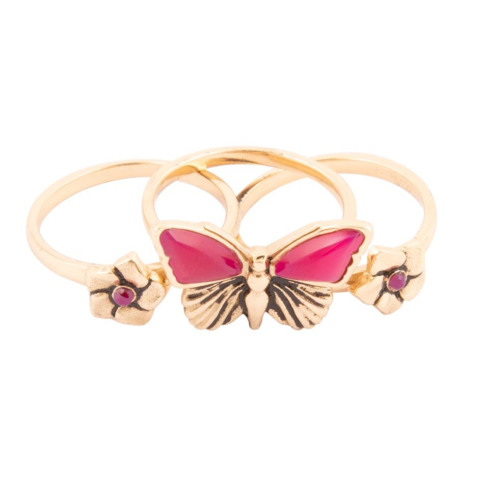 Gold ring with a pink butterfly design on a white background