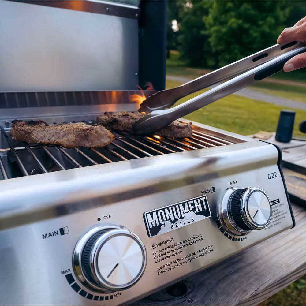 Person grilling on a Monument Grills barbecue with tongs