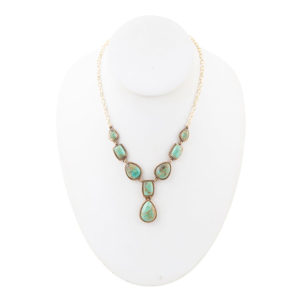 Necklace with turquoise stones on a white mannequin bust