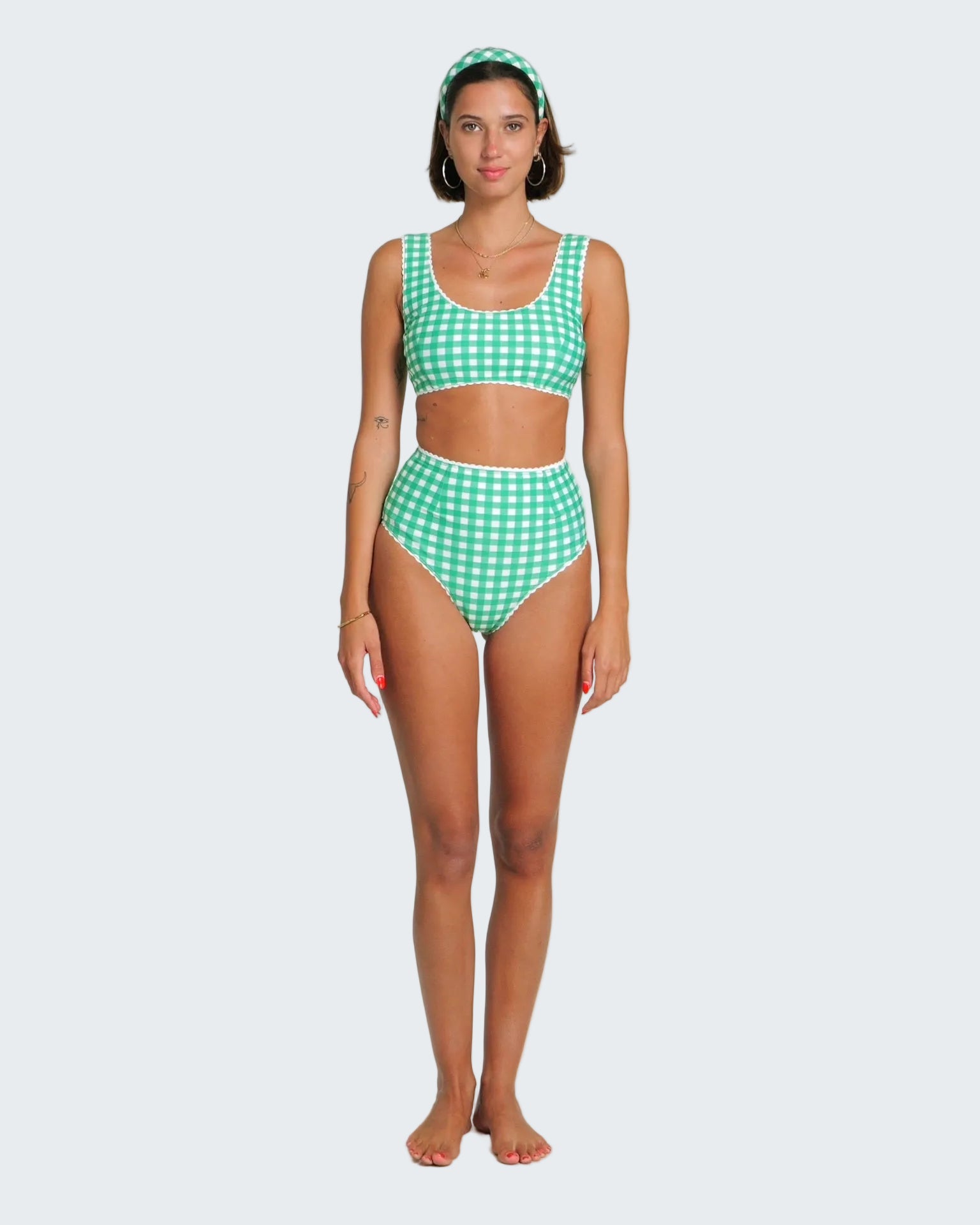 Woman wearing a green checkered bikini set on a white background