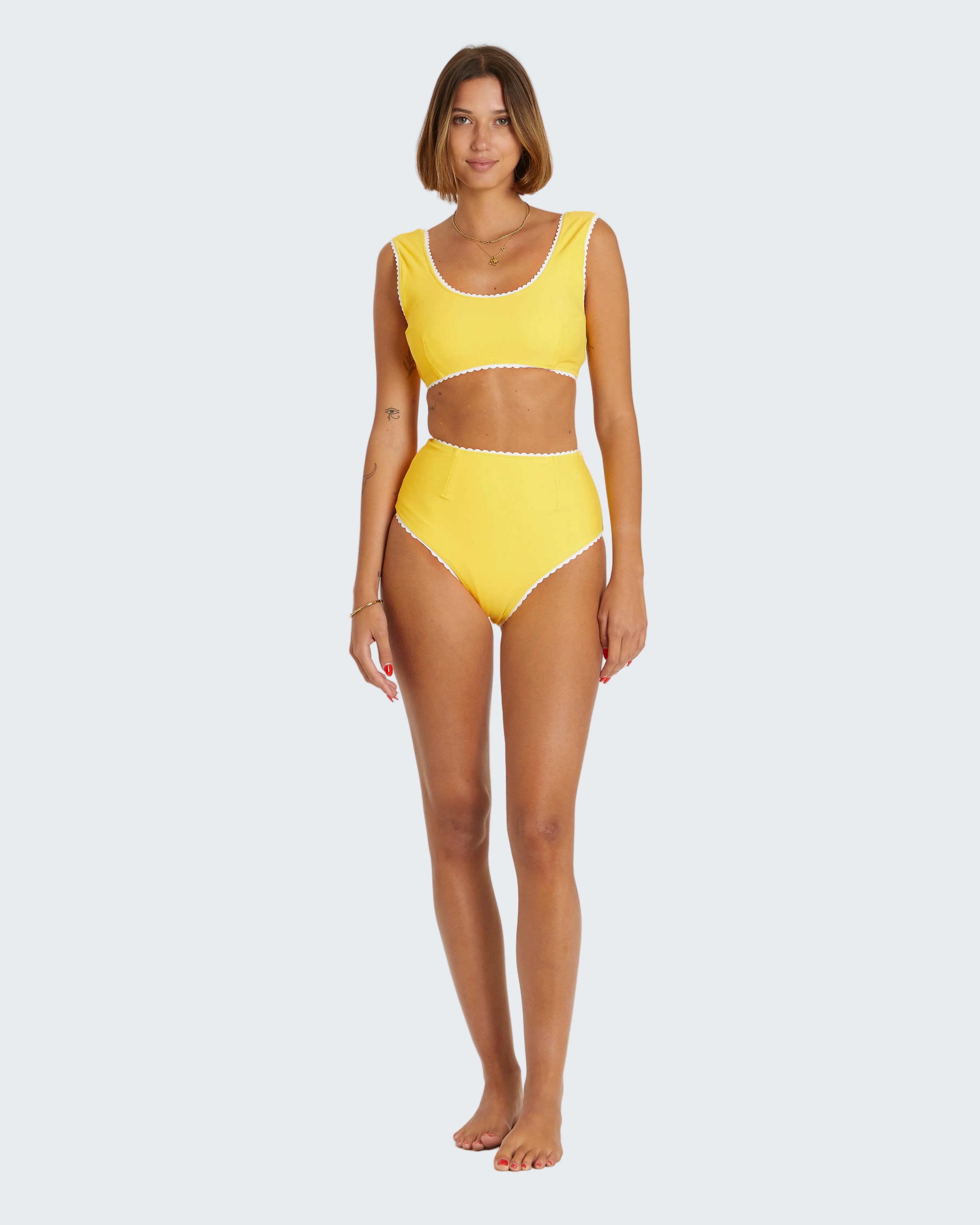 Woman wearing a yellow bikini set on a white background