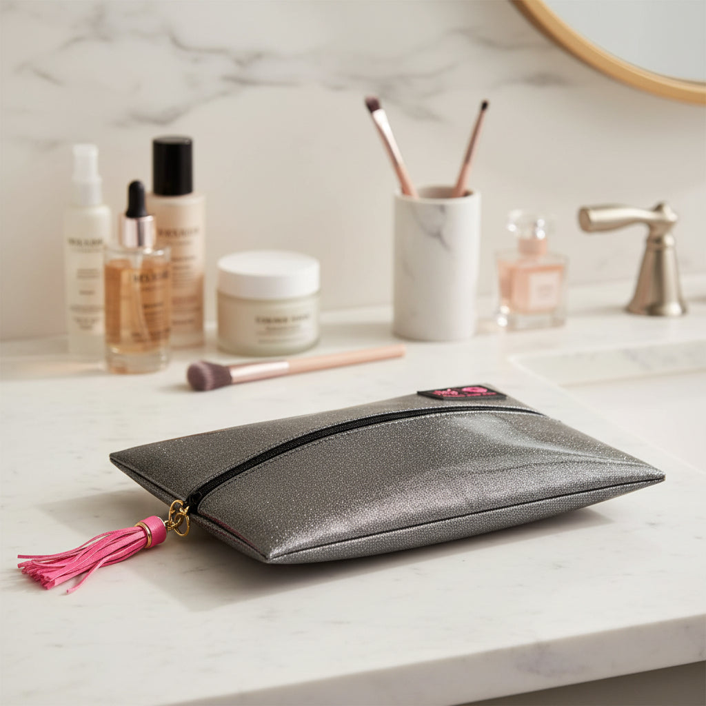 Glittery makeup bag with a pink tassel on a light gray background