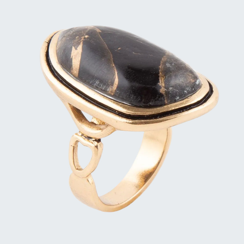 Gold ring with a large black stone on a white background