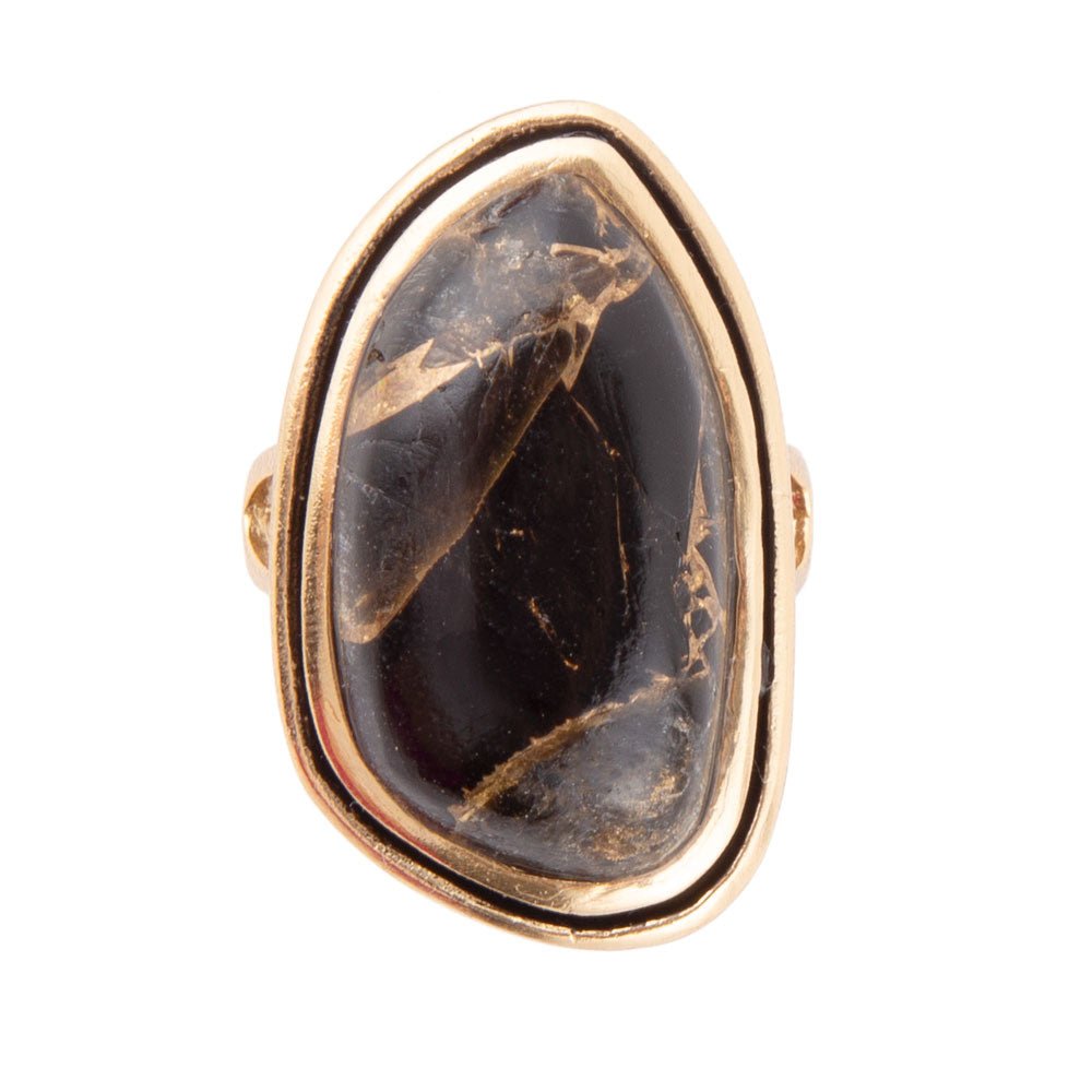 Ring with a large black stone and gold accents on a white background