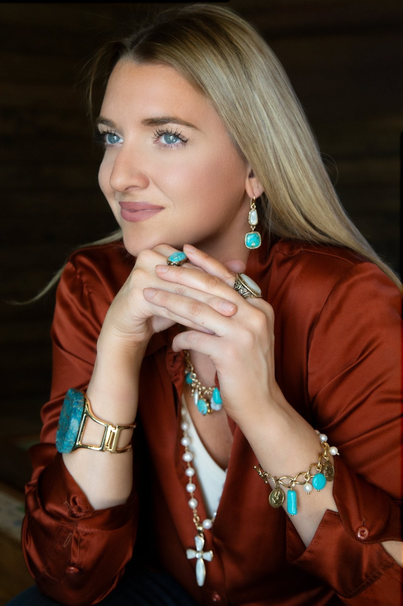 Woman wearing turquoise jewelry against a dark background