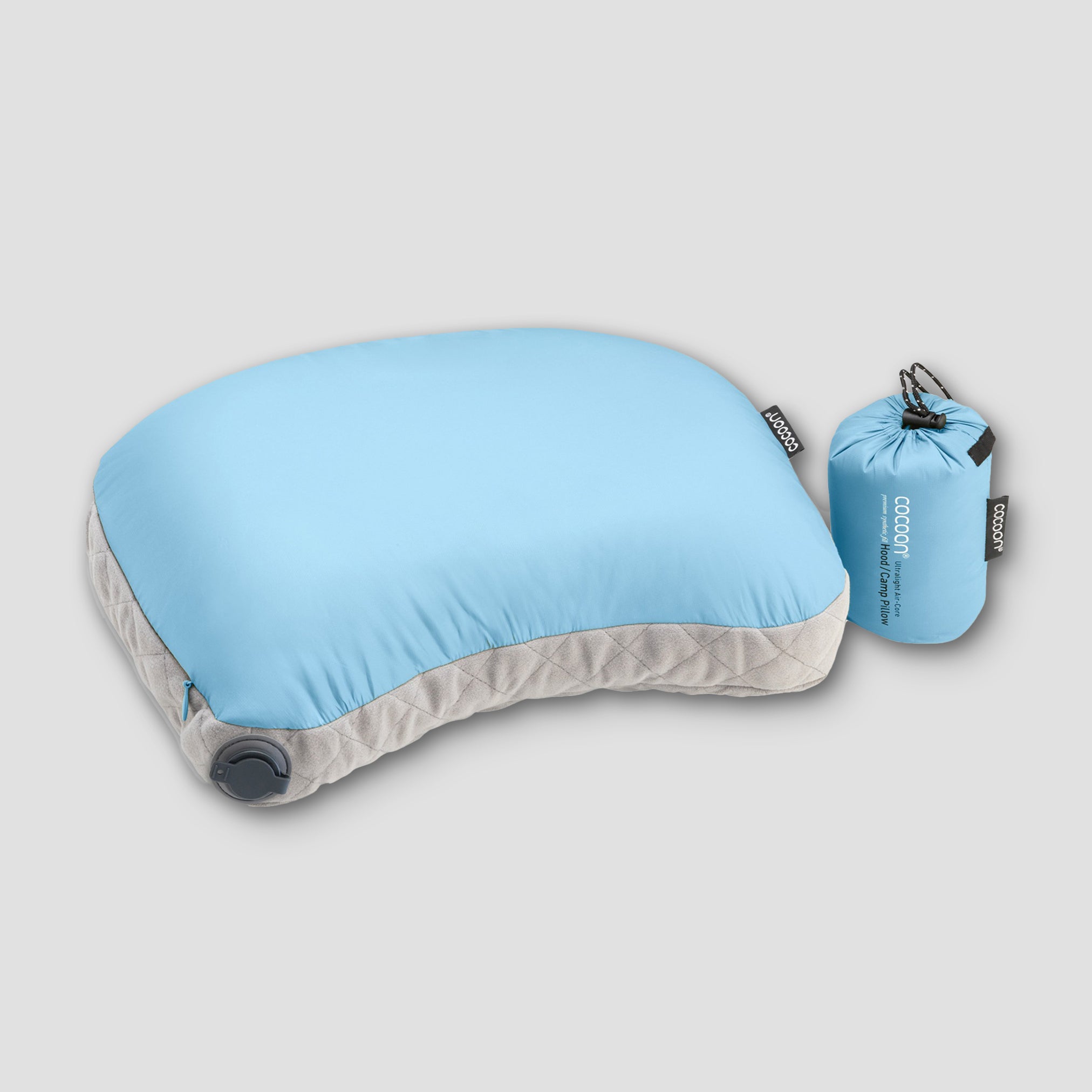 Blue inflatable travel pillow with its carrying pouch on a light gray background